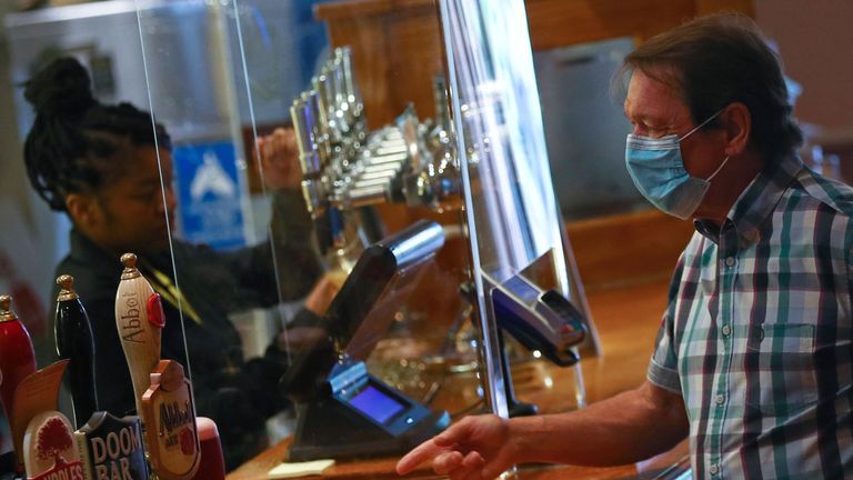 A customer is seen at a bar at The Holland Tringham Wetherspoons pub after it reopened following the outbreak of the coronavirus disease (COVID-19), in London, Britain July 4, 2020