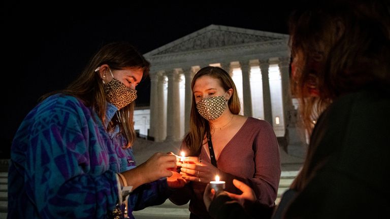 People light candles in front of the US Supreme Court