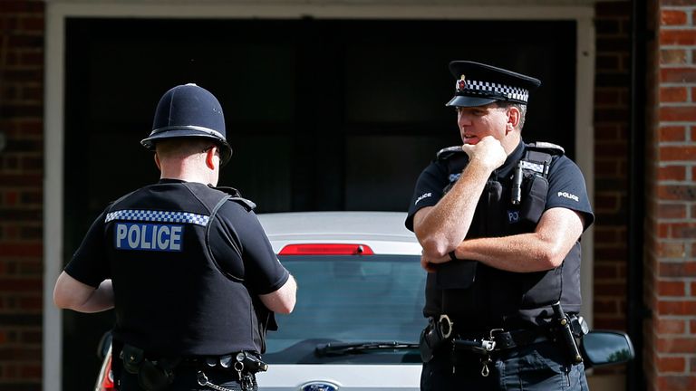 Police officers stand outside the house of Saad al-Hilli and his family in Claygate near London in 2012