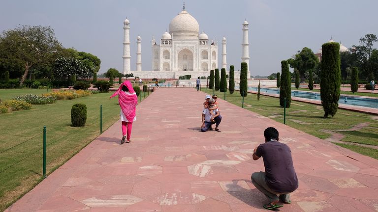 A man gets his photo taken in front of the Taj Mahal after the monument reopens for the first time in six months