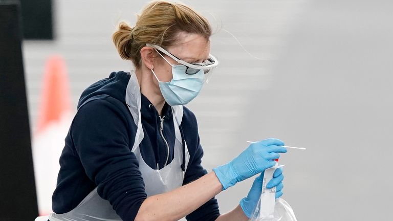 A nurse takes a swab at a COVID-19 drive-through testing station in Manchester