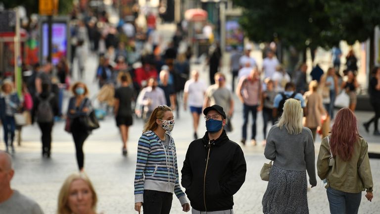 A couple wearing protective face coverings chat in the street in Liverpool city centre, north-west England on September 18, 2020 after the British government imposed fresh restrictions on the city after an rise in cases of the novel coronavirus. - Millions more people in northern and central England faced new restrictions over a surge in coronavirus cases, the British government announced on Friday, as it warned another national lockdown could be imminent. Tighter regulations preventing people from socialising with anyone outside their household will come into force from next Tuesday across parts of the northwest, the Midlands and West Yorkshire. Food and drink venues in the northwestern areas of Merseyside, Warrington, Halton and Lancashire will be restricted to table service only, while pubs and bars will have to shut early by 10:00 pm (2100 GMT). (Photo by Oli SCARFF / AFP) (Photo by OLI SCARFF/AFP via Getty Images)