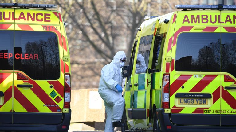 A member of the ambulance service wearing personal protective equipment is seen leading a patient (unseen) into an ambulance at St Thomas' Hospital in London on March 24, 2020. - Britain's leaders on Tuesday urged people to respect an unprecedented countrywide lockdown, saying that following advice to stay at home would stop people dying of coronavirus. (Photo by DANIEL LEAL-OLIVAS / AFP) (Photo by DANIEL LEAL-OLIVAS/AFP via Getty Images)