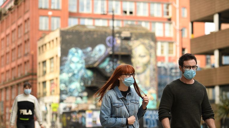 Pedestrians wear face-masks in Manchester on October 16, 2020, as the number of cases of the novel coronavirus COVID-19 rises. - The government on Thursday announced more stringent measures but as ministers tightened the screw on social interaction to cut close-contact transmission, they sparked a furious row with leaders in northwest England, where infection rates are highest. Greater Manchester Mayor Andy Burnham accused the government of being "willing to sacrifice jobs and businesses here to try and save them elsewhere". (Photo by Oli SCARFF / AFP) (Photo by OLI SCARFF/AFP via Getty Images)