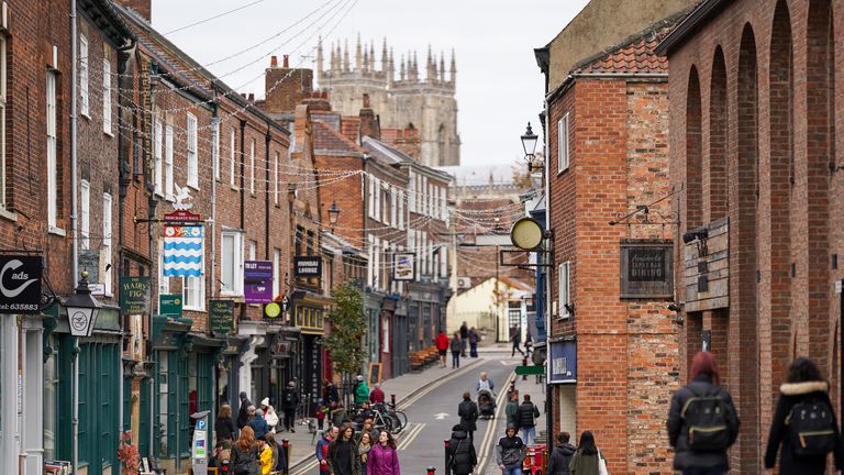 YORK, ENGLAND - OCTOBER 18: Visitors walk through the centre of York on October 18, 2020 in York, England. York city has become another of England’s high risk areas placed under 'Tier 2' coronavirus lockdown measures as Government data indicates the R number range for the whole of the UK had increased slightly from between 1.2 and 1.5 last week to 1.3 and 1.5. Most notably the change will introduce a ban on people from different households from mixing anywhere indoors, prompting particular concern within the already badly-affected hospitality industry. (Photo by Ian Forsyth/Getty Images)