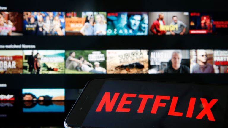 PARIS, FRANCE - MARCH 28: In this photo illustration, the Netflix media service provider&#39;s logo is displayed on the screen of an iPhone in front of a television screen on March 28, 2020 in Paris, France. Faced with the coronavirus crisis, Netflix will reduce visual quality for the next 30 days, in order to limit its use of bandwidth. (Photo Illustration by Chesnot/Getty Images)