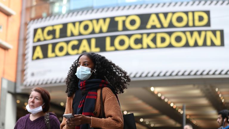 A woman wearing a face mask walks to Manchester.  Greater Manchester will be kept under strict coronavirus control after last-ditch talks with the prime minister aimed at securing additional financial support without a deal.