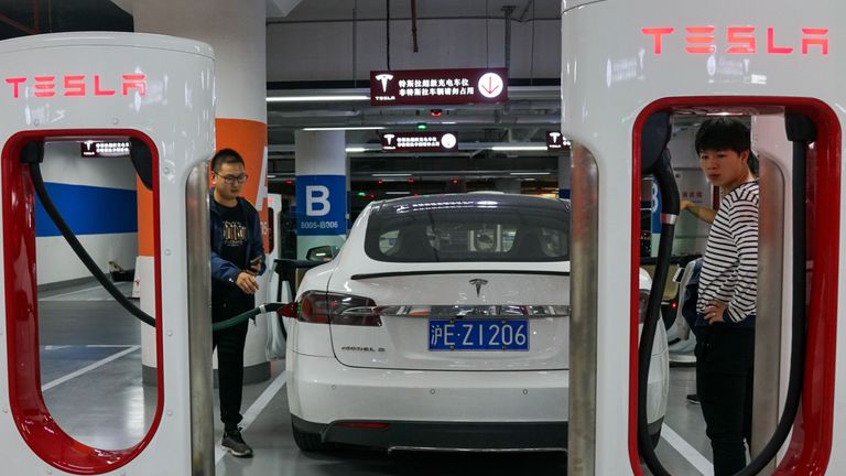People charge their Tesla vehicles at a charging station inside a mall in Shanghai on October 23, 2017. - Tesla has reached an agreement with Shanghai authorities that would make it the first foreign automaker to build its own plant in China, putting it in the driver's seat in the world's biggest electric-vehicle market, the Wall Street Journal reported. (Photo by CHANDAN KHANNA / AFP)        (Photo credit should read CHANDAN KHANNA/AFP via Getty Images)