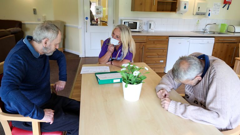 Care worker Cath Roe talks to residents William Buxton and Neil Fox on her rounds at Ashwood Court residential care home in Lowton, Warrington, as it reopens to visitors for the first time since lockdown began in March.