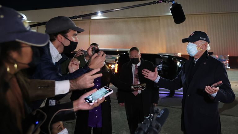 Joe Biden talks to reporters in Michigan wearing two face masks