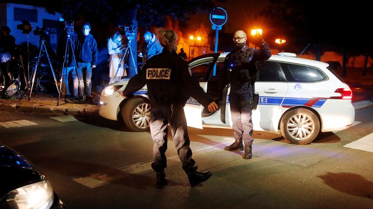 Police officers secure the area near the scene of a stabbing attack in the Paris suburb of Conflans St Honorine, France, October 16, 2020