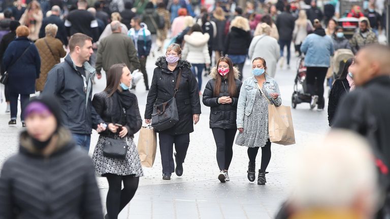 People wear masks in Liverpool city centre where new virus restrictions are in place 