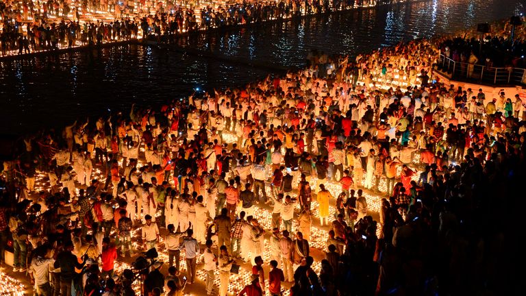 TOPSHOT - Hindu devotees light earthen lamps on the banks of the River Sarayu on the eve of "Diwali" festival during an event organised by the Uttar Pradesh government, in Ayodhya on October 26, 2019. - "Diwali", the Festival of Lights, marks victory over evil and commemorates the time when Hindu god Lord Rama achieved victory over Ravana and returned to his kingdom Ayodhya. (Photo by SANJAY KANOJIA / AFP) (Photo by SANJAY KANOJIA/AFP via Getty Images)
