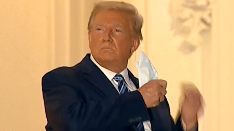 Donald Trump removes his mask after returning to the White House from a stay in hospital with coronavirus