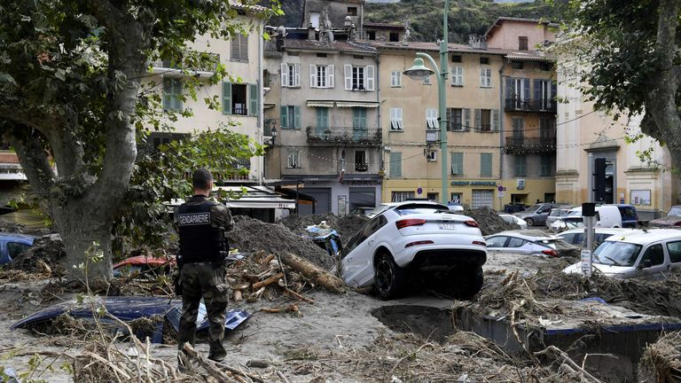 A gendarme stands amongst debris including vehicles in Breil-sur-Roya, south-eastern France, on October 4, 2020, after extensive flooding caused widespread damage in the Alpes-Maritimes departement.