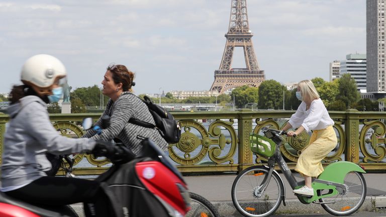 Parisiens in masks near the Eiffel Tower
