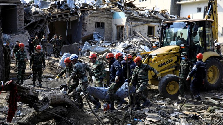 Search teams carry a body from the site of an alleged rocket attack in Ganja, Azerbaijan