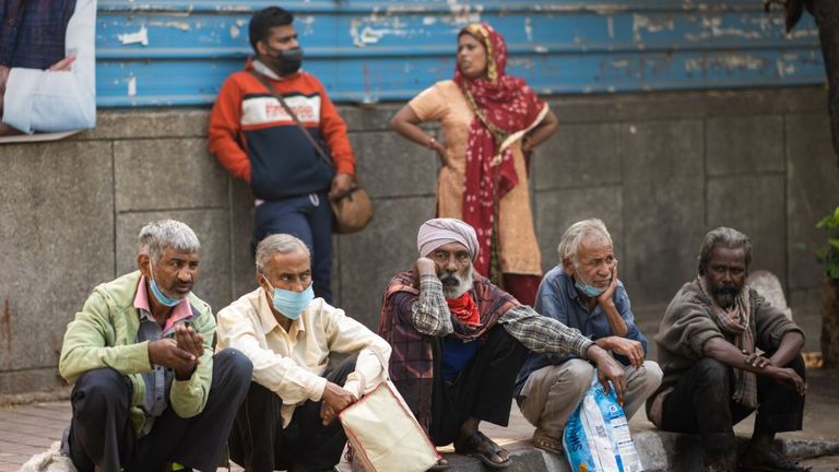 People wait at a street outside a temple to get free food in New Delhi on October 29, 2020. - India on October 29 passed eight million coronavirus cases, with the world&#39;s second-worst-hit country bracing for a possible second wave ahead of winter and a series of religious festivals. (Photo by Jewel SAMAD / AFP) (Photo by JEWEL SAMAD/AFP via Getty Images)