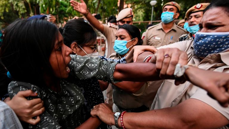 A female student clashes with police in a protest in New Delhi