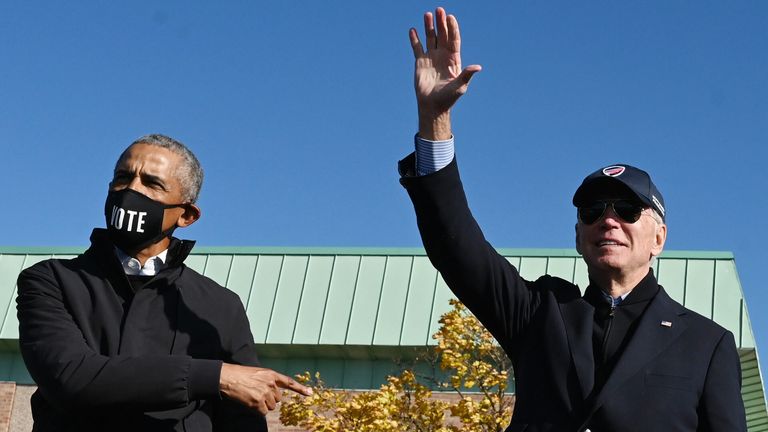 FLINT, MI - OCTOBER 31: Former U.S. President Barack Obama and Democratic presidential nominee Joe Biden wave to the crowd at the end of a drive-in campaign rally at Northwestern High School on October 31, 2020 in Flint, Michigan. Biden is campaigning with former President Obama on Saturday in Michigan, a battleground state that President Donald Trump narrowly won in 2016. (Photo by Drew Angerer/Getty Images)