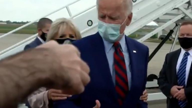 Jill Biden pulled her husband Joe back a little as he was talking to reporters - in an attempt to to maintain correct social distancing