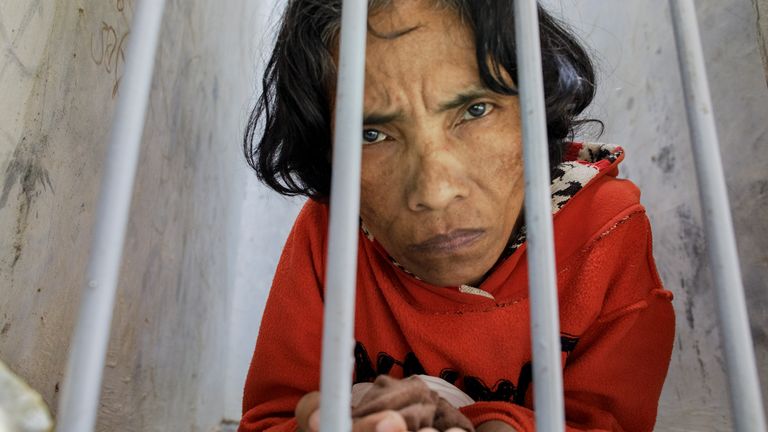 A woman with a psychosocial disability lives confined in a bare narrow cell at madrasah Ar-Ridwan, a private Islamic healing center in Cilacap, Central Java, Indonesia.
