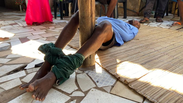 A man with a mental health condition lies on the floor with his legs tied around a wooden pole and his arms in a straitjacket at a church outside Maputo, Mozambique. The church pastor provides spiritual guidance and uses the word of God to “fight evil spirits.”
