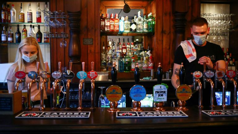 Bartenders pour drinks in a pub 