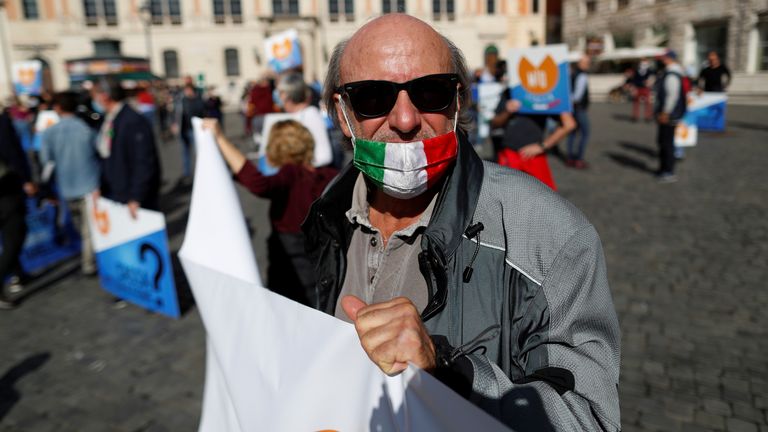 Demonstrators protest against restrictive measures put in place to fight COVID-19, in Rome
A demonstrator wears a protective mask with the Italian flag during a protest against restrictive measures put in place to fight the coronavirus disease (COVID-19) infections in Rome, Italy, October 25, 2020. REUTERS/Yara Nardi