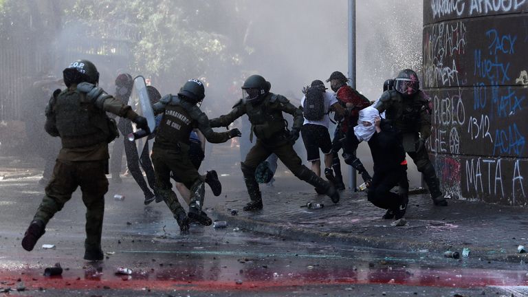 Riot police clash with demonstrators on the streets of Santiago 