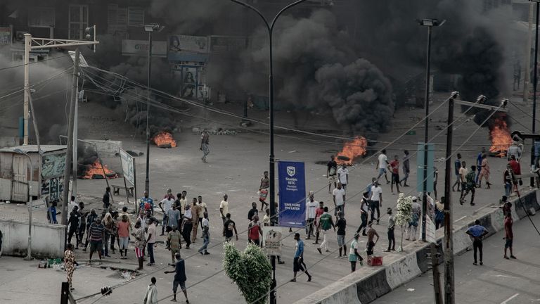 People  are seen near burning tires on the street, in Lagos (UnEarthical/via Reuters) 