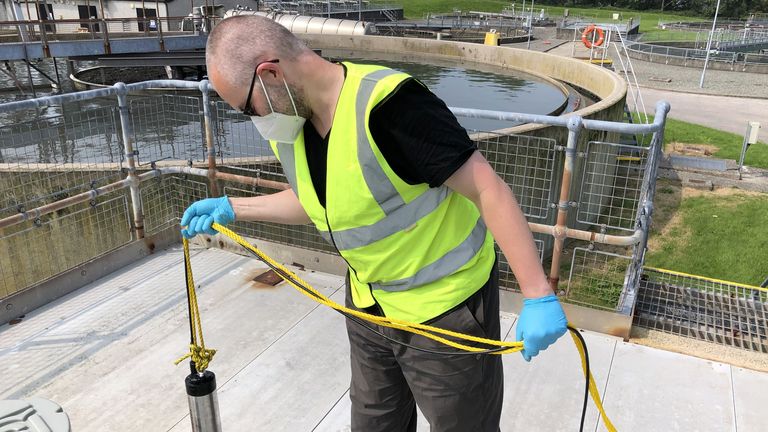 Taking a sample of raw sewage at the sewage treatment plant before testing sewage for coronavirus