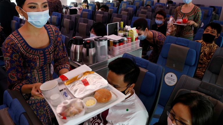 Singapore Airlines stewardesses serve food on board the economy class cabin of their A380 restaurant at Changi Airport in Singapore October 24, 2020. REUTERS/Edgar Su