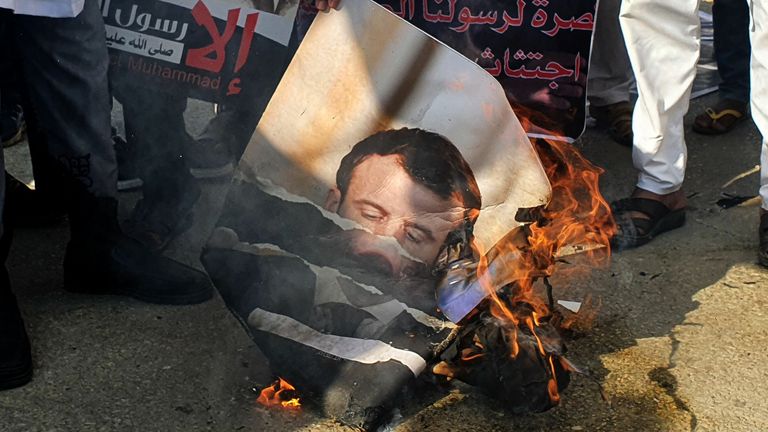 Protesters burn a portrait of French President Emmanuel Macron in Tripoli 