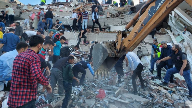 People search for survivors at a collapsed building in Izmir