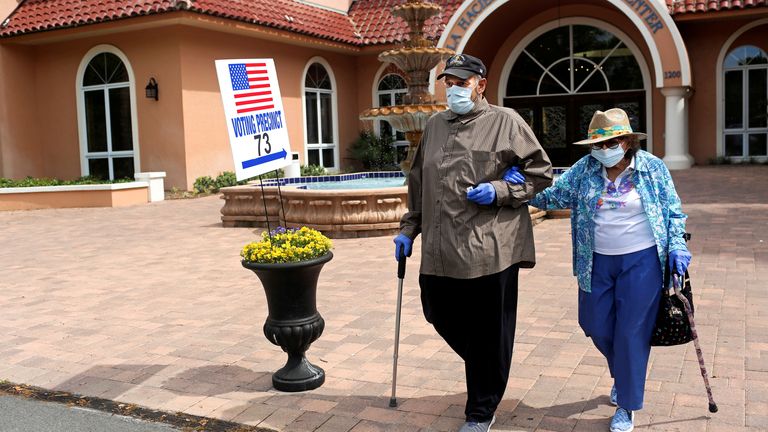 Rick Hatfield, 73, walks with his mother, Marie Rossi, 93, wearing face masks to protect himself from coronavirus disease (COVID-19) outside La Hacienda Recreation Center, as voters cast their votes in the Democratic primary in The Villages, Florida.  , United States, March 17, 2020