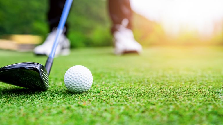 Close up golf ball on green grass field. sport golf club