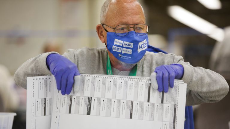 Election worker Charles Sundberg of Kent, Washington opens ballot envelopes at the King County Elections office on Election Day in Renton, Washington on November 3, 2020. - Americans were voting on Tuesday under the shadow of a surging coronavirus pandemic to decide whether to reelect Republican Donald Trump, one of the most polarizing presidents in US history, or send Democrat Joe Biden to the White House. (Photo by Jason Redmond / AFP) (Photo by JASON REDMOND/AFP via Getty Images)