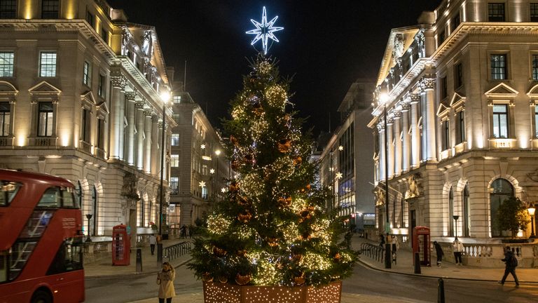 LONDON, ENGLAND - NOVEMBER 19: A Christmas tree is illuminated on Lower Regent Street on November 19, 2020 in London, England. The United Kingdom is currently under coronavirus lockdown restrictions, with pubs, restaurants and non-essential retailers ordered to close until December 2. With the busy Christmas period approaching, the British government is yet to confirm whether traditional festivities will be able to go ahead. (Photo by Dan Kitwood/Getty Images)