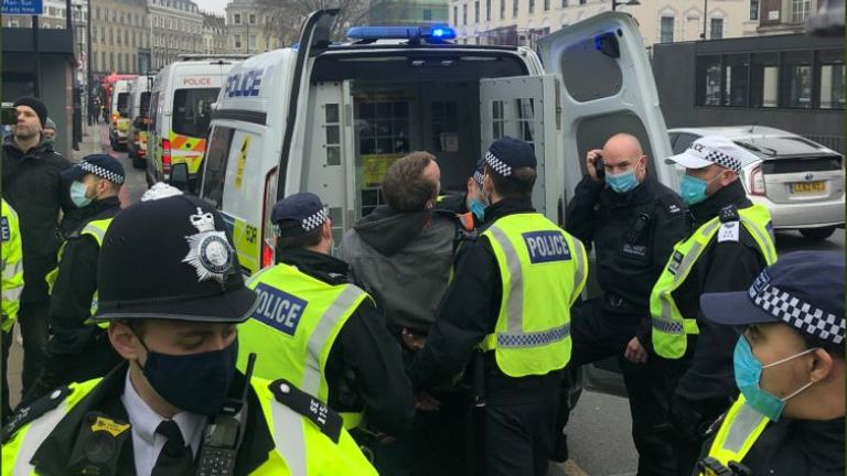 A man is detained by police during an anti-lockdown protest in London