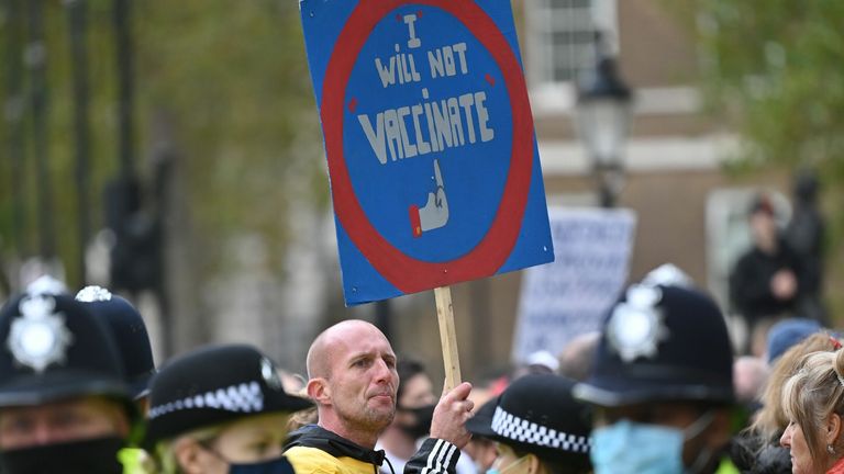 A demonstrator carries an anti-vaccination sign at a protest action against restrictions imposed during the novel coronavirus COVID-19 pandemic, outside Downing Street, central London on October 10, 2020