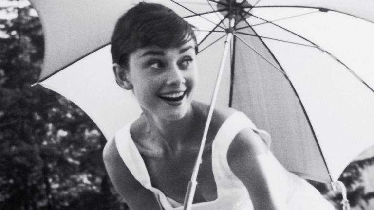 PMC49Y Audrey Hepburn playing golf and holding a parasol, circa 1955. Pic: PictureLux /The Hollywood Archive /Alamy Stock Photo