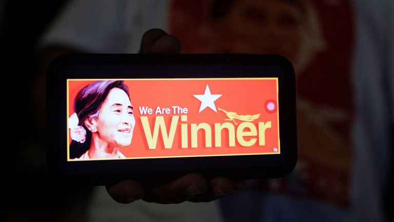 Eine Person zeigt ein Foto des myanmarischen Staatsberaters Aung San Suu Kyi auf einem Handy, während Anhänger der Nationalen Partei für Demokratie (NLD) nach den Parlamentswahlen in Yangon, Myanmar, am 8. November 2020, außerhalb des Parteizentrums auf Ergebnisse warten.  REUTERS / Shwe Paw Mya Tin