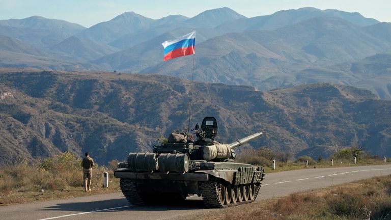 A service member of the Russian peacekeeping troops walks near a tank near the border with Armenia, following the signing of a deal to end the military conflict between Azerbaijan and ethnic Armenian forces, in the region of Nagorno-Karabakh, November 10, 2020. REUTERS/Francesco Brembati