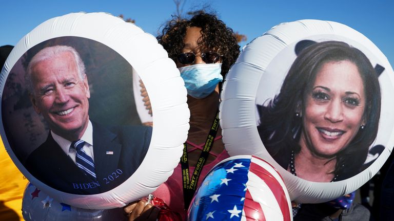 A supporter of U.S. Democratic presidential candidate Joe Biden holds balloons with the faces of Joe Biden and Kamala Harris as he celebrates near the site of a planned election victory celebration after media declared Biden the winner of the 2020 United States Presidential Election in Wilmington.  Delaware, USA, November 7, 2020. REUTERS / Kevin Lamarque
