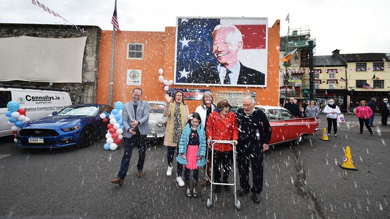 Joe Blewitt a cousin of Joe Biden sprays a bottle of champagne along with family members underneath a mural of Presidential candidate Joe Biden as locals celebrate in anticipation of Biden being elected as the next US President in Ballina, Ireland