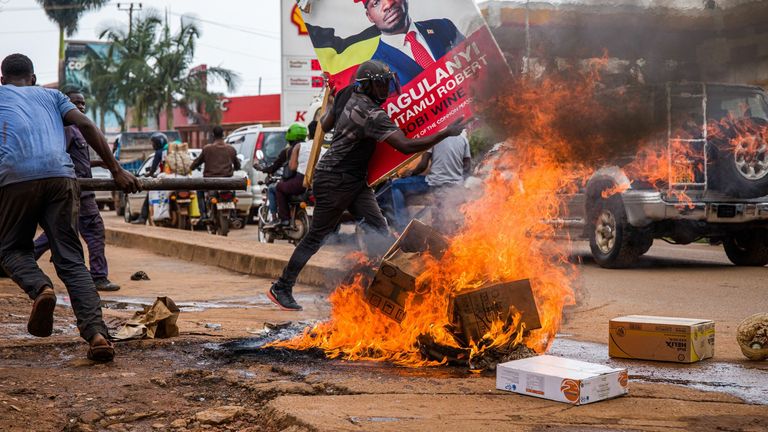 A Bobi Wine supporter carrying a campaign poster during protests 