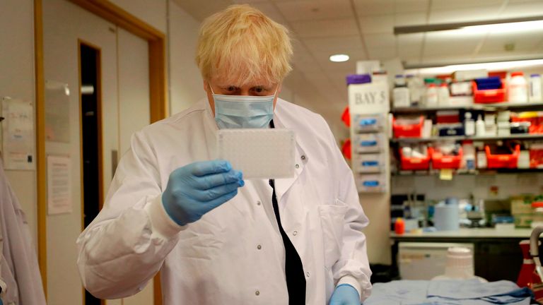 Britain&#39;s Prime Minister Boris Johnson looks at an immunological assay as he washes them during a visit to the Jenner Institute in Oxford, central England, on September 18, 2020, where the Prime Minister toured the laboratory and met scientists who are leading the covid-19 vaccine research. - Millions more people in northern and central England faced new restrictions over a surge in coronavirus cases, the British government announced on Friday, as it warned another national lockdown could be imm