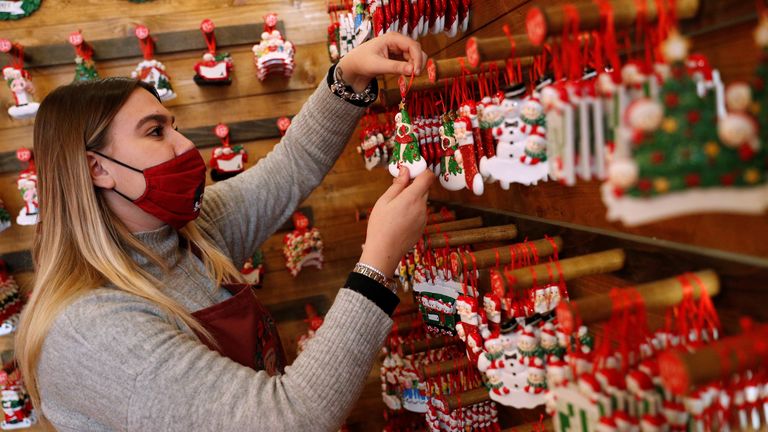 A shop assistant in a Christmas shop in Rome, Italy