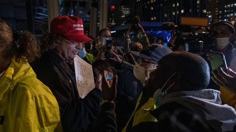 A supporter of US President Donald Trump talks with protesters of different political views outside of the TCF center where ballots are being counted in downtown Detroit, Michigan on November 4, 2020. - Democratic presidential challenger Joe Biden on November 4 neared the magic number of 270 electoral votes needed to win the White House with several battleground states still in play, as incumbent President Donald Trump challenged the vote count. (Photo by SETH HERALD / AFP) (Photo by SETH HERALD
